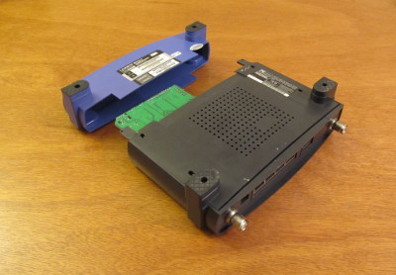 Photograph of a WRT 54G unit, with the case fully separated from the front panel and main circuit board.