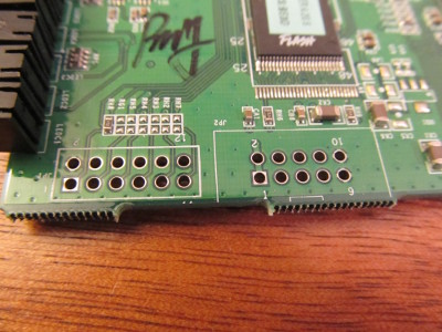 Close-up photograph of unpopulated pinholes for JTAG and TTL connections.